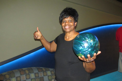 Woman smiling with bowling ball